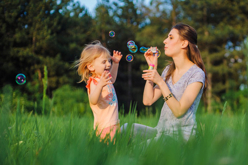 mom and child blowing bubbles